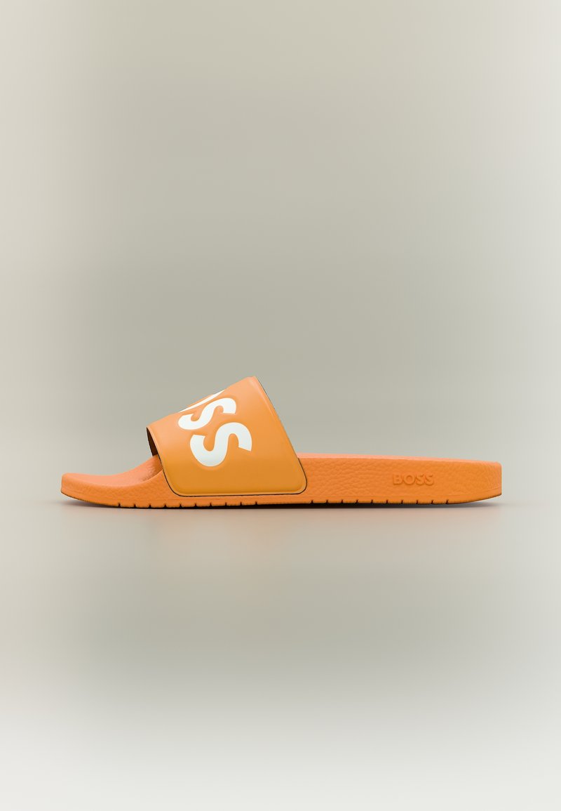 Pomarańczowa sandałka na ślizgu z białym napisem "BOSS" na pasku i teksturowaną podeszwą, przedstawiona z profilu na neutralnym tle.