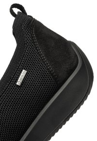 Zwarte instapschoen met textuurgebreide stof, suède hiel, dikke rubberen zool, trekkoordje en een klein GORE-TEX-label aan de zijkant.