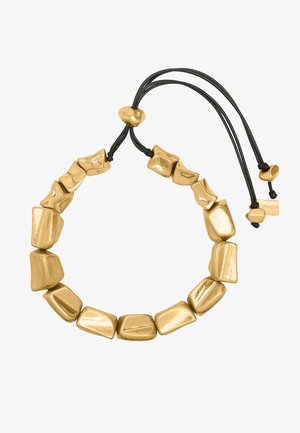 Bransoletka z nieregularnymi koralikami w złotym kolorze nawleczonymi na czarny regulowany sznurek z zapięciami w kolorze złotym.