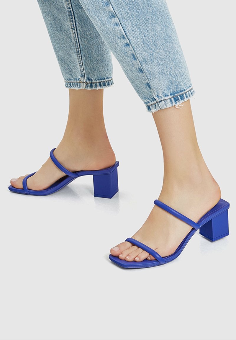 Sandales à talons blocs bleues avec deux fines lanières, design à bout carré, matériau synthétique lisse et dos ouvert.