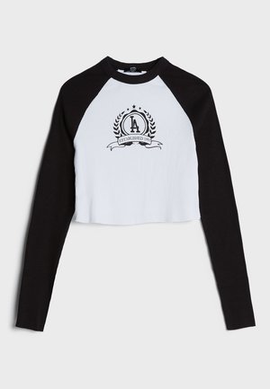 Sort og hvid cropped skjorte med lange ærmer og "LA Established 1991" emblem centreret på brystet.