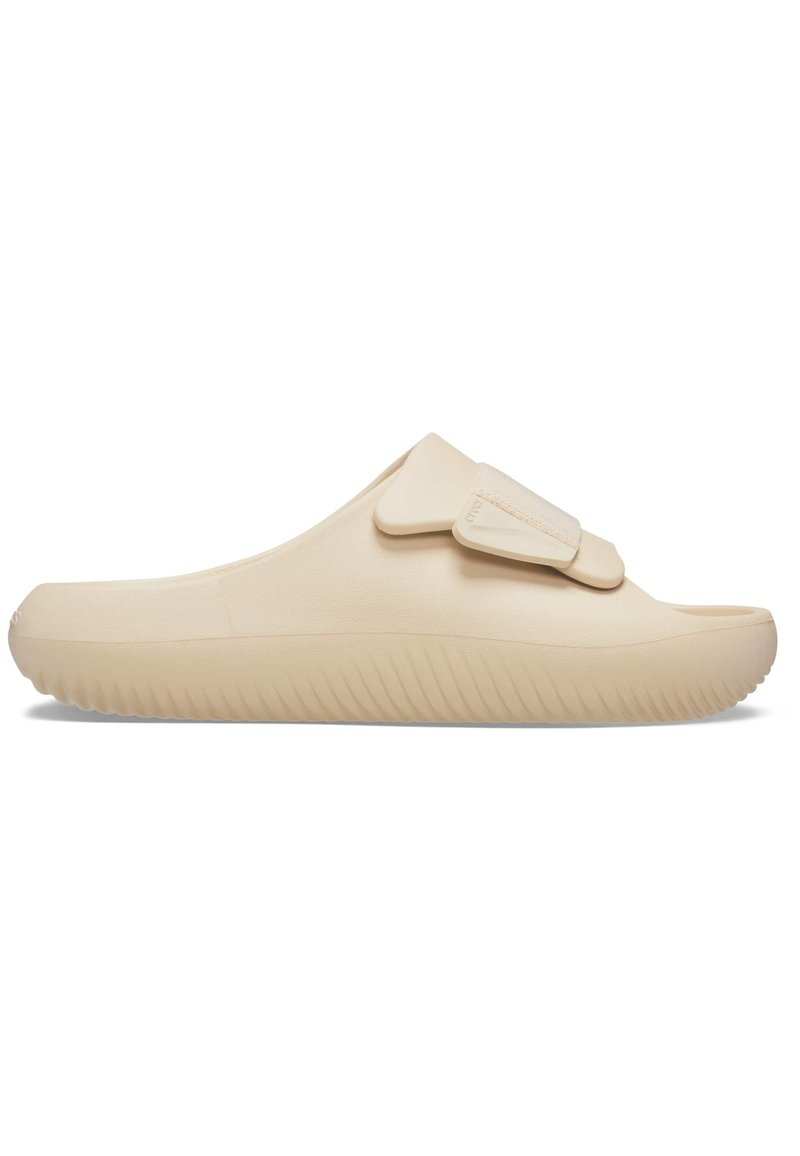Beige instapsandal met een gladde, matte afwerking, voorzien van een enkele verstelbare band en een geribbelde zool voor betere grip.