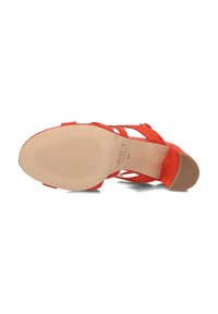 Rode suède sandalen met hoge hakken, voorzien van kruisende banden, een open teen ontwerp en een geprofileerde beige buitenzool met groeven voor grip.