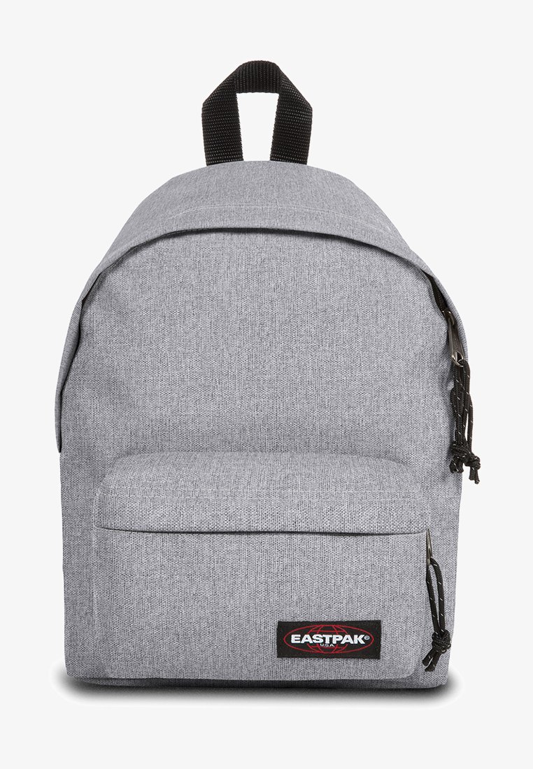 Mochila de tela gris con forma redondeada, un bolsillo frontal con cremallera y acentos negros. Las correas ajustables tienen un acabado texturizado.