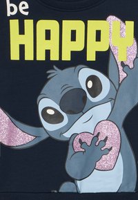 Granatowa bluza z kapturem z kreskówkową postacią o dużych oczach, błyszczącym różowym sercem i wyraźnym zielonym napisem "be HAPPY". Miękka faktura, casualowy design.