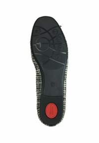 Suela de goma negra con un patrón texturizado y acentos circulares. La parte superior presenta un material tejido en tonos neutros con un detalle del logo rojo. Talla 37.