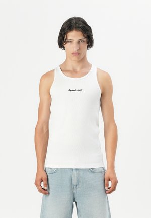 White ribbed tank top with a round neckline and thin shoulder straps, featuring subtle black text embroidered on the chest. Worn with light blue jeans.