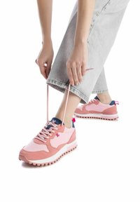 Zapatillas deportivas rosas con un diseño de materiales mixtos, que presentan ante y malla, suela blanca, acentos azules y cordones en contraste.