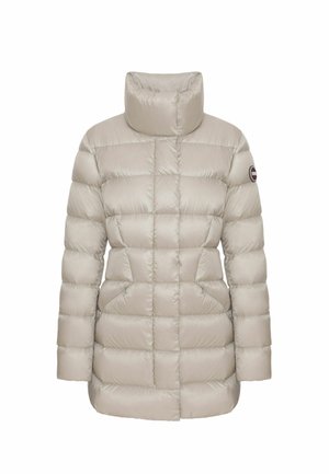 Bēšas pūkainas jakas ar augstu apkakli, kvadrātu tekstūru, izteiktu šuvju, un sānu kabatām. Uz piedurknes ir logotipa uzlīme.