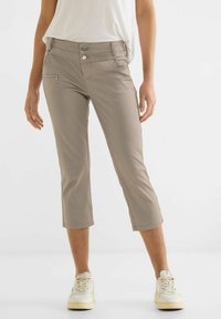 Beige korta byxor med framficka, dragkedjedetalj och uppvikta fållar. Tillverkade av ett mjukt tyg, med dubbelknappsstängning.