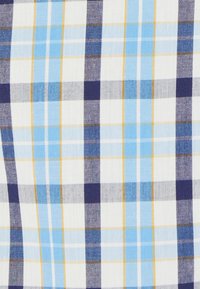 Tejido de algodón con un diseño de cuadros en azul y azul marino, con acentos en blanco y amarillo. Tejido texturizado con cuadros grandes y pequeños alternos.