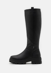 Bota negra de cuero texturizado hasta la rodilla, con punta redondeada, silueta ajustada, suela de goma gruesa con estrías y una tira en la parte superior.