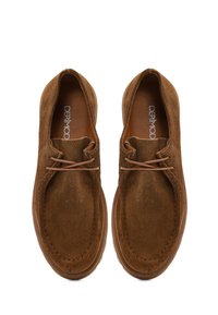 Brown suede shoes with rounded toe, minimalistic design, featuring light brown laces and a textured surface. Brand logo inside.