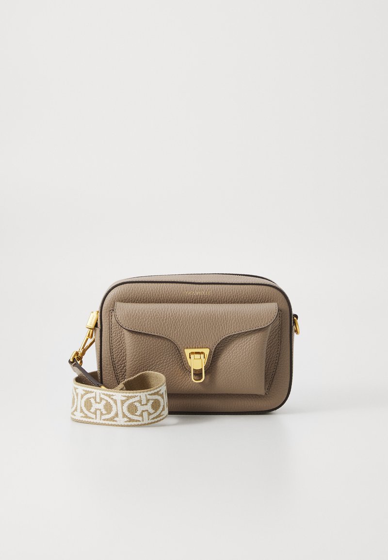 Rjav usnjen crossbody torbica z sprednjim poklopcem, z zlatim okovjem in patterned tkano naramnico. Dimenzije so kompaktene, idealne za nujne stvari.