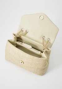 Tkaná béžová kabelka s texturovaným povrchem, zlatými řetízkovými uchy a krémovým koženým interiérem s kapsou na zip a patentním uzávěrem.