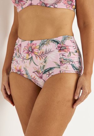Vrouw draagt een roze bikinionderdeel met hoge taille en een meerkleurige tropische bloemenprint, torso zichtbaar van borst tot bovenbenen.