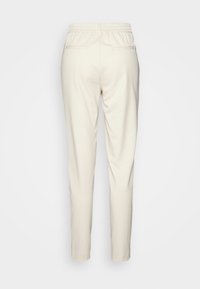 Lys beige bukser med elastisk talje, slim fit og to baglommer. Glat stof og minimalistisk design.