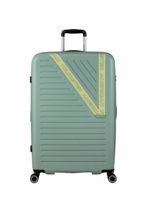 Maleta rígida en un suave verde menta, con estrías verticales, una banda con el logotipo diagonal, ruedas negras y mango retráctil.