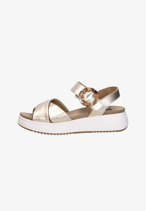 Sandale femme métallisée or avec semelle blanche épaisse, brides croisées à l'avant et bride de cheville avec boucle ronde effet écaille.