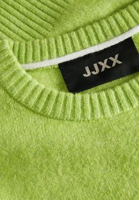 Strickpullover in leuchtendem Grün, mit einem gerippten Hals, weichem Material und einem schwarzen Etikett mit weißer Aufschrift "JJXX."