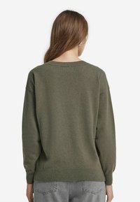 Olivgrüner Pullover mit lockerer Passform, Rundhalsausschnitt und langen Ärmeln. Mit gerippten Bündchen und Saum, aus einem weichen, strukturierten Material gefertigt.