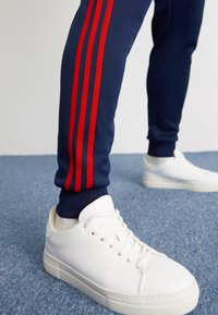 adidas Originals SST TP - Treniņtērpa apakšdaļas - night indigo/better scarlet