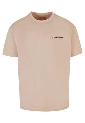 Beige Baumwoll-T-Shirt mit Rundhalsausschnitt und kurzen Ärmeln, mit einem schwarzen Drucklogo "MJGONZALES™" auf der oberen linken Seite.