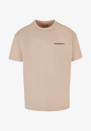 Beige Baumwoll-T-Shirt mit Rundhalsausschnitt und kurzen Ärmeln, mit einem schwarzen Drucklogo "MJGONZALES™" auf der oberen linken Seite.