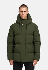 Žalia pūkinė striukė su aukštu apykakle ir reguliuojama kapišonu, turinti priekinį užtrauktuką ir spaustukus bei šonines kišenes. Lygus paviršius.