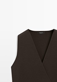 Dunkelbraune ärmellose Strickweste mit V-Ausschnitt und einem Etikett mit der Aufschrift "Massimo Dutti" am Halsausschnitt.