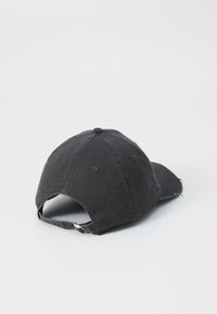 Cappello in cotone nero con visiera curva, bordi usurati, strap regolabile sul retro e design a sei pannelli con dettagli di cucitura.