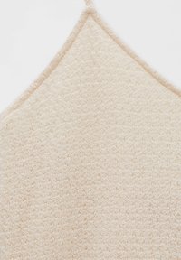 Camiseta de punto beige con un patrón texturizado, tirantes finos y escote en forma de V. Tejido suave con un aspecto ligero.