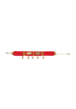 Bracelet tissé rouge avec accents dorés, présentant des formes ovales décoratives en or et des perles dorées pendantes, fini avec un fermoir et une chaîne d'extension.