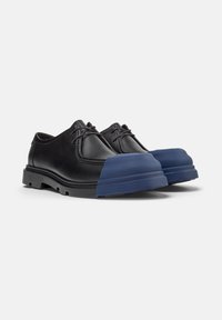 Zapatos de cuero negros con una puntera de goma azul única, que cuentan con cordones y un diseño de suela resistente para mayor durabilidad.