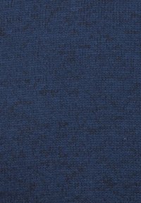 Marinblått texturerat tyg med ett fint stickat mönster, som uppvisar en mjuk känsla och subtil djup i ton. Lämpligt för olika textilapplikationer.