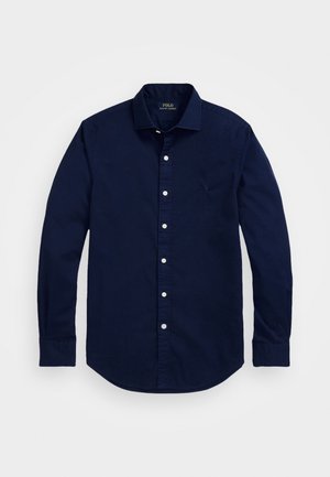 Chemise bleu marine à manches longues avec boutons, col, boutons blancs, ourlet arrondi et logo brodé sur la poitrine.