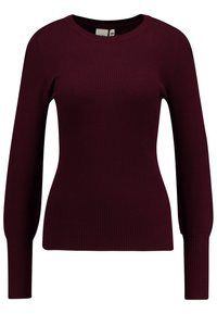 Burgunderfarbener Rippenstrickpullover mit langen Ärmeln und rundem Ausschnitt, der eine figurbetonte Form hat und die Körperkonturen betont.