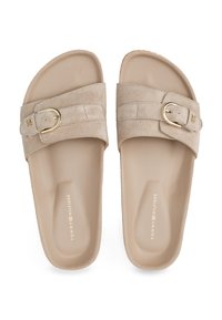 Sandale slide din suede bej, cu un bradă lată și un cataramă aurie, având o talpă căptușită. Numele mărcii este embosat pe interiorul sandalelor.