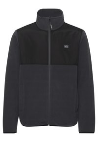 Chaqueta de forro polar en gris oscuro con un panel negro en la parte superior del pecho. Presenta un cuello alto, cremallera frontal y bolsillos laterales. Diseño simple.