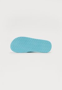 Talpa unei sandalete flip-flop cu un model texturat unduitor în nuanțe de albastru deschis, prezentată pe un fundal alb simplu.