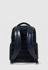 Donkerblauwe rugzak met gewatteerde textuur, ritssluiting en verstelbare banden. Voorzien van een glanzend materiaalaccent en contrasterende blauwe hardware.