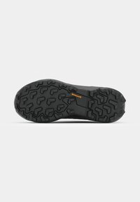 Semelle de chaussure noire avec motif de bande de roulement profond et petit logo orange "Continental" au centre, isolée sur fond blanc.