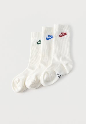 Kolm paari valgeid meeskonnakinga sokke soonilise tekstuuriga, igaüks erineva värvi Nike logoga: roheline, sinine ja punane.