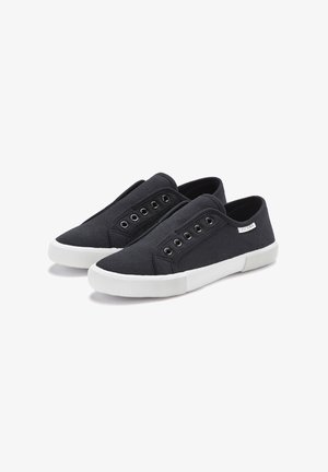 Black canvas slip-on shoes with white rubber soles, featuring five pairs of eyelets and a small logo tag on the side.