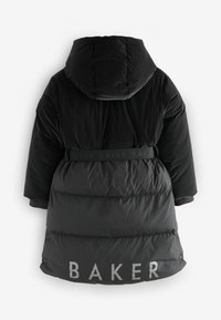 Melnā pūkainā jaka ar kapuci, ar savilktu jostasvietu. Aizmugurē ir uzdrukāts "BAKER". Gluda tekstūra ar kvadrātveida apdruku.