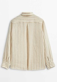 Chemise à rayures verticales beige et blanche à manches longues, avec poignets boutonnés et pli creux au dos sous la découpe épaules.