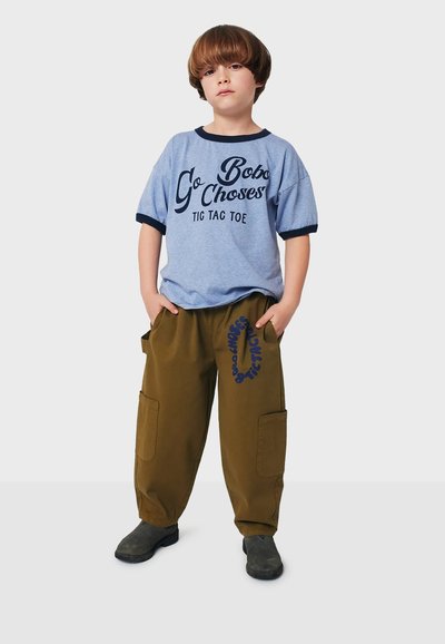 Blue short-sleeve T-shirt with black trim, featuring "Go Bobo Chooses" text; khaki cargo pants with pockets and navy print design. Black shoes.