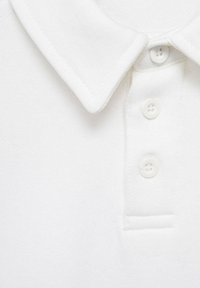 Weißes Poloshirt mit klassischem Kragen, Drei-Knopf-Leiste und weichem, strukturiertem Stoff. Keine sichtbaren Muster oder Akzente.