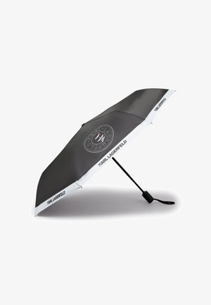 Schwarzer Klappregenschirm mit weißem Rand und dem Schriftzug "Karl Lagerfeld", versehen mit einem kreisförmigen Logo mit einem stilisierten Katzenkopf in der Mitte.