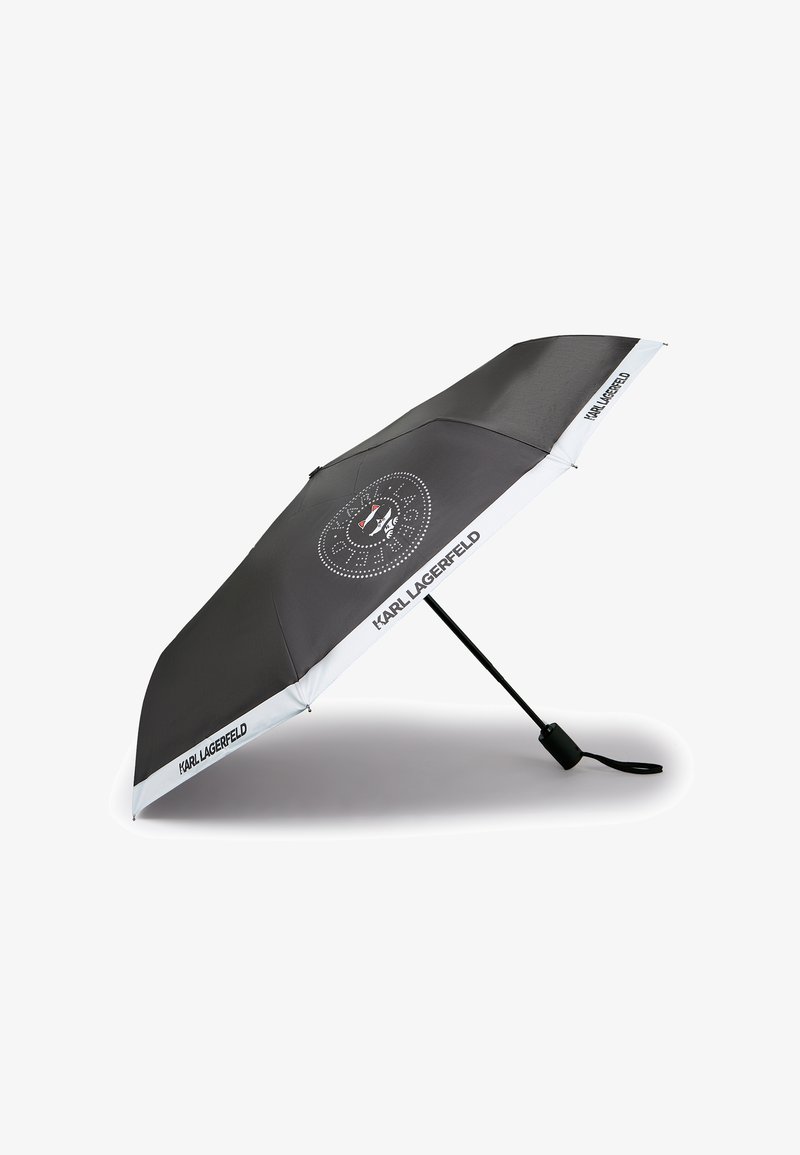 Μαύρη ομπρέλα που διπλώνει με λευκό περίγραμμα και το κείμενο "Karl Lagerfeld", με ένα κυκλικό λογότυπο που παρουσιάζει μια στυλιζαρισμένη γάτα στο κέντρο.